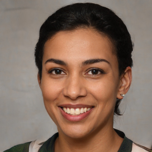 Joyful latino young-adult female with medium  brown hair and brown eyes