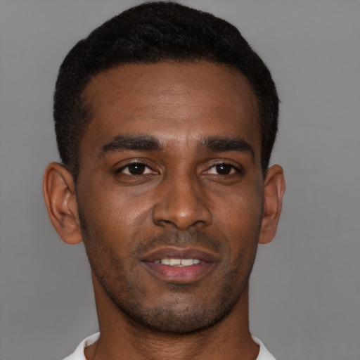Joyful black young-adult male with short  brown hair and brown eyes