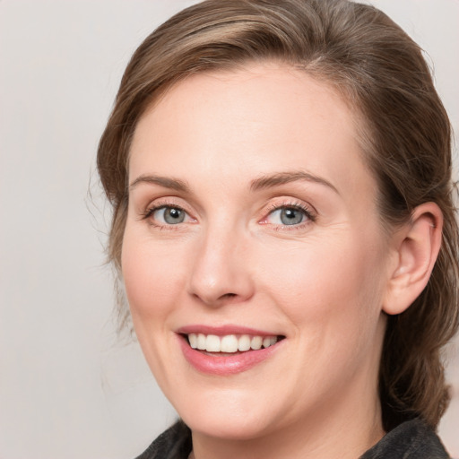 Joyful white adult female with medium  brown hair and blue eyes