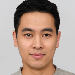 Joyful asian young-adult male with short  black hair and brown eyes