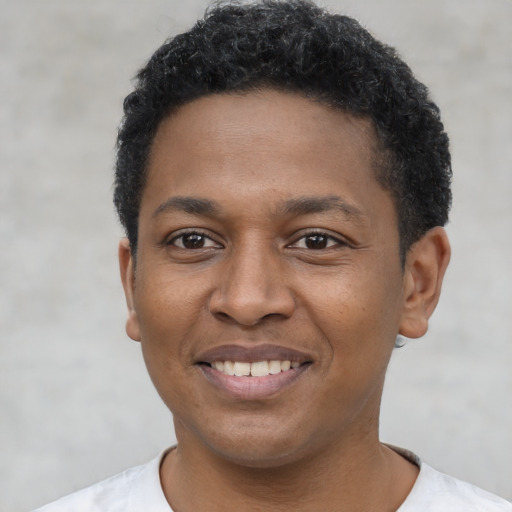 Joyful black young-adult male with short  black hair and brown eyes