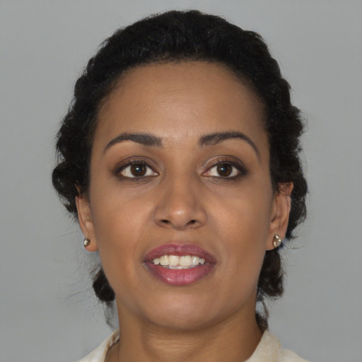Joyful black young-adult female with medium  brown hair and brown eyes