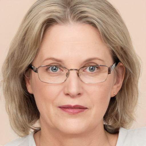 Joyful white adult female with medium  brown hair and blue eyes