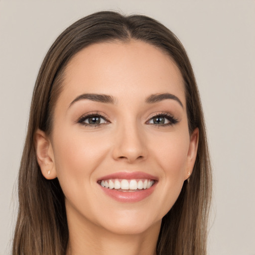 Joyful white young-adult female with long  brown hair and grey eyes