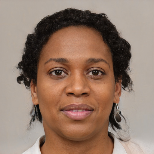 Joyful black adult female with medium  brown hair and brown eyes