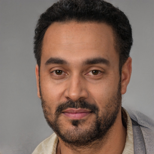 Joyful latino adult male with short  black hair and brown eyes