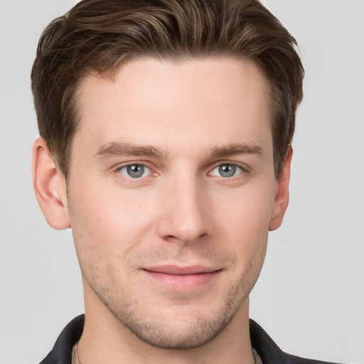 Joyful white young-adult male with short  brown hair and grey eyes