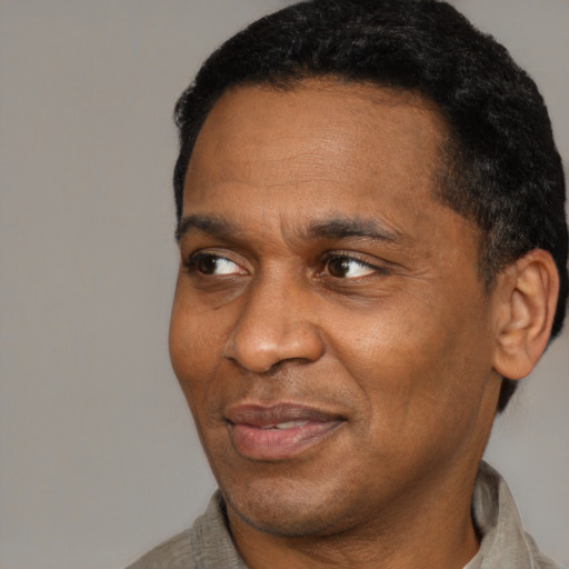 Joyful black adult male with short  brown hair and brown eyes
