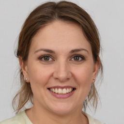 Joyful white young-adult female with medium  brown hair and grey eyes