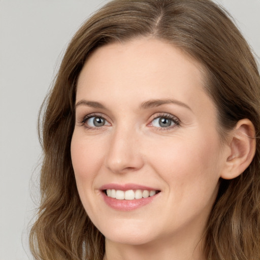 Joyful white young-adult female with long  brown hair and blue eyes