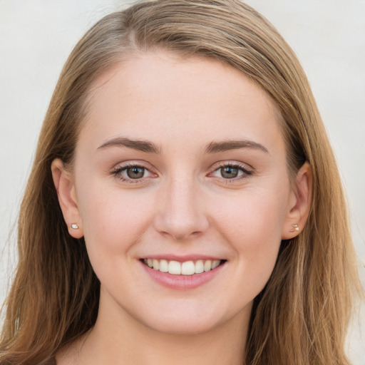 Joyful white young-adult female with long  brown hair and blue eyes