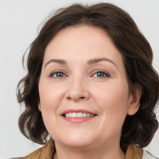 Joyful white adult female with medium  brown hair and brown eyes