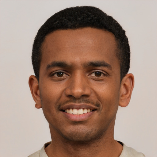 Joyful black young-adult male with short  black hair and brown eyes