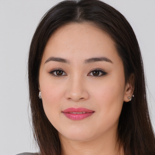 Joyful asian young-adult female with long  brown hair and brown eyes