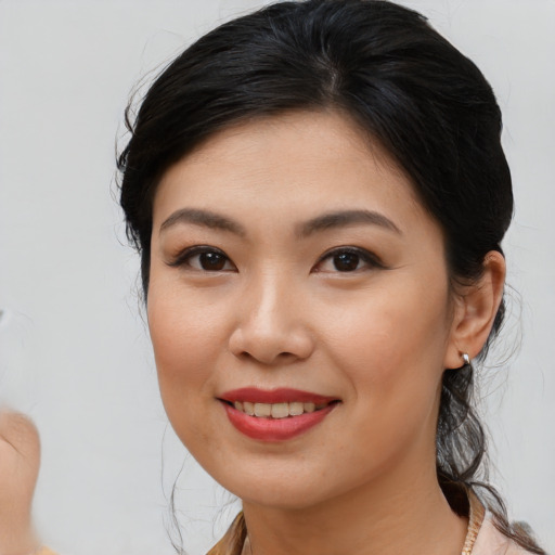 Joyful asian young-adult female with medium  brown hair and brown eyes