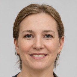 Joyful white adult female with medium  brown hair and grey eyes