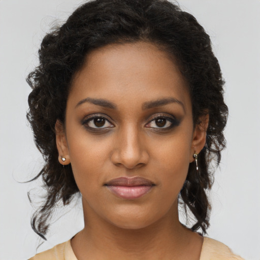 Joyful black young-adult female with long  brown hair and brown eyes