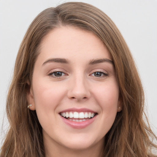 Joyful white young-adult female with long  brown hair and grey eyes