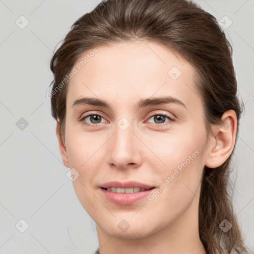 Joyful white young-adult female with medium  brown hair and grey eyes