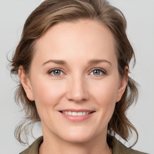 Joyful white young-adult female with medium  brown hair and grey eyes