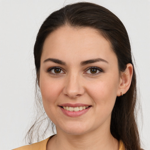 Joyful white young-adult female with long  brown hair and brown eyes