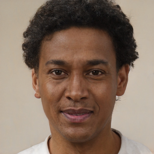 Joyful black adult male with short  brown hair and brown eyes