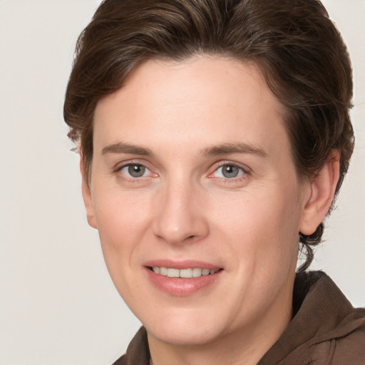 Joyful white young-adult female with medium  brown hair and grey eyes