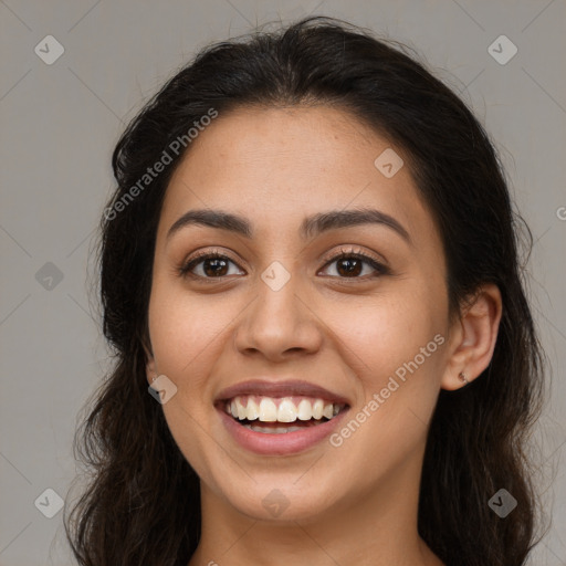 Joyful latino young-adult female with long  brown hair and brown eyes