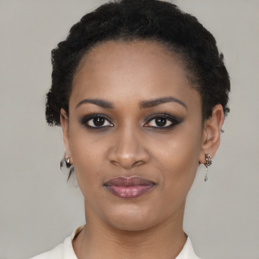 Joyful black young-adult female with short  black hair and brown eyes