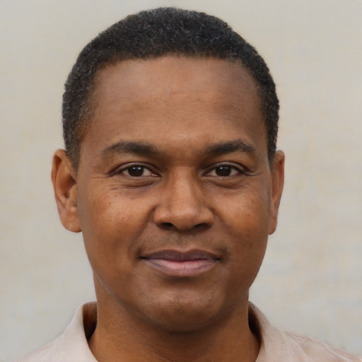 Joyful black young-adult male with short  brown hair and brown eyes