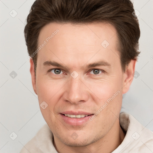 Joyful white adult male with short  brown hair and grey eyes