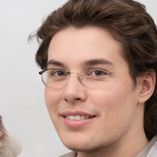 Joyful white young-adult male with medium  brown hair and grey eyes