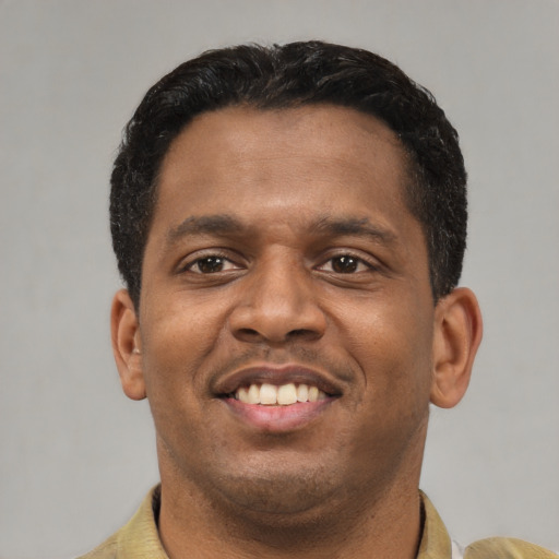 Joyful latino young-adult male with short  black hair and brown eyes