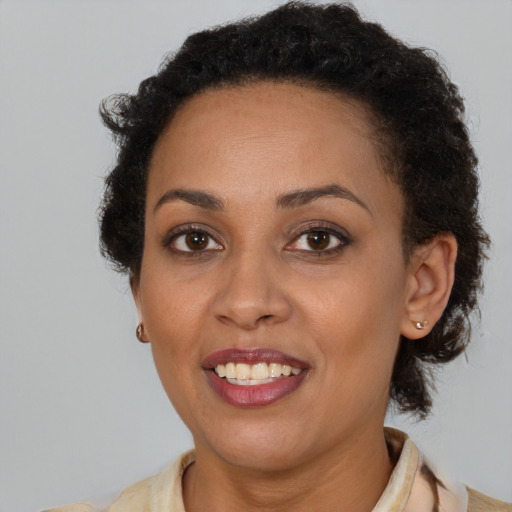 Joyful black young-adult female with short  brown hair and brown eyes