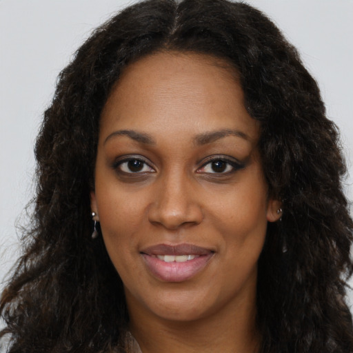 Joyful black young-adult female with long  brown hair and brown eyes