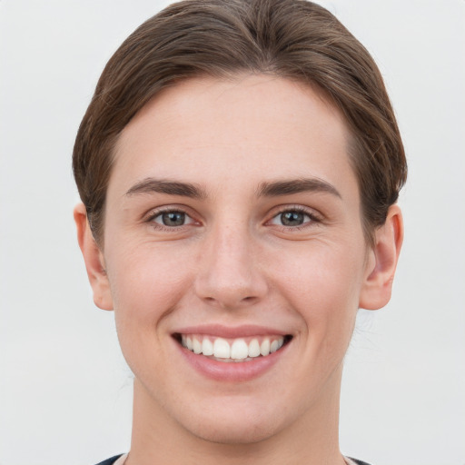 Joyful white young-adult female with short  brown hair and grey eyes