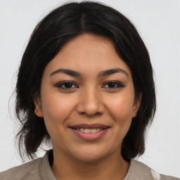 Joyful latino young-adult female with medium  brown hair and brown eyes