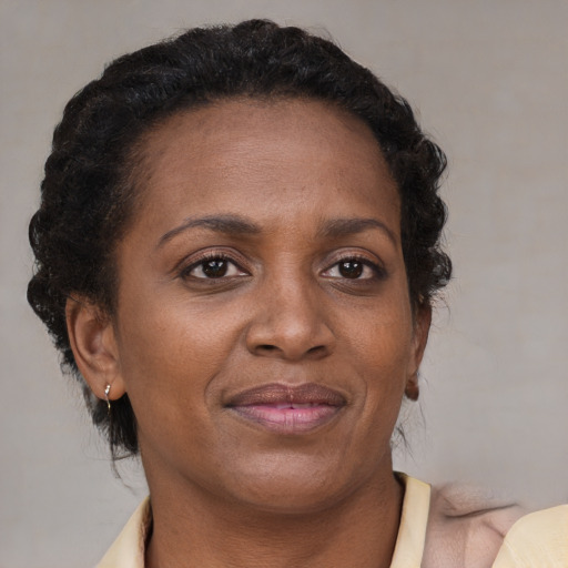 Joyful black adult female with short  brown hair and brown eyes