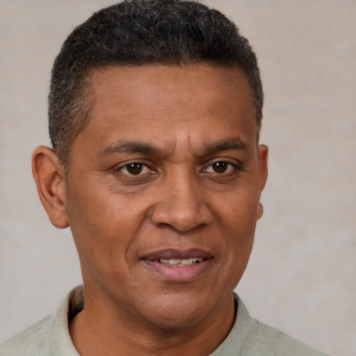 Joyful black adult male with short  brown hair and brown eyes