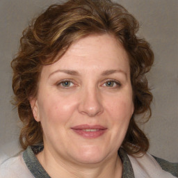 Joyful white adult female with medium  brown hair and blue eyes