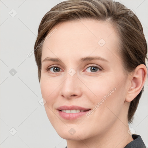 Joyful white young-adult female with medium  brown hair and grey eyes