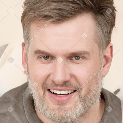 Joyful white adult male with short  brown hair and grey eyes