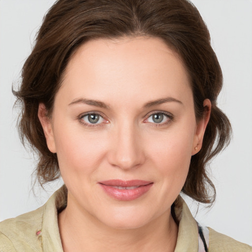 Joyful white young-adult female with medium  brown hair and grey eyes