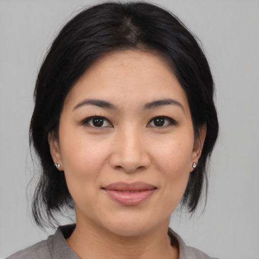 Joyful asian young-adult female with medium  brown hair and brown eyes
