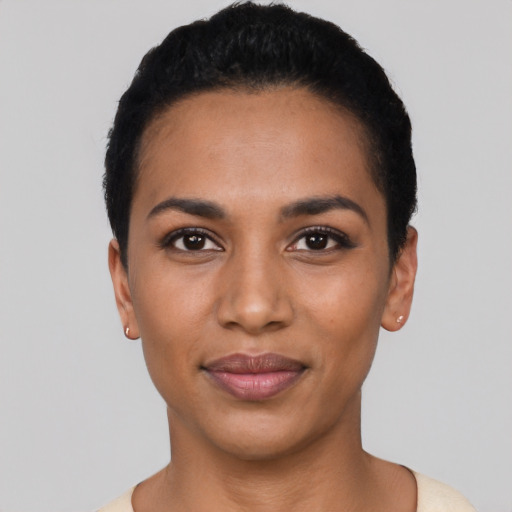 Joyful latino young-adult female with short  black hair and brown eyes