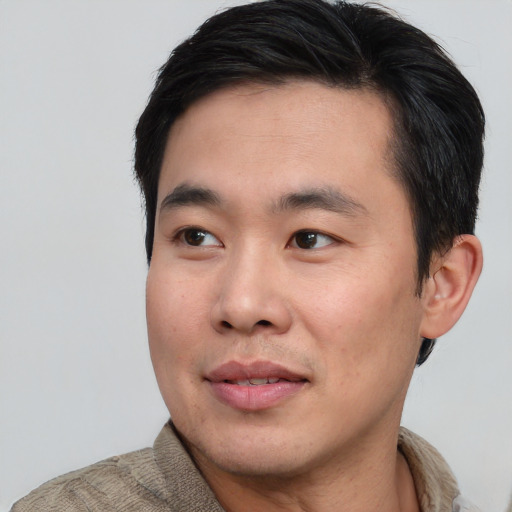Joyful asian young-adult male with short  black hair and brown eyes