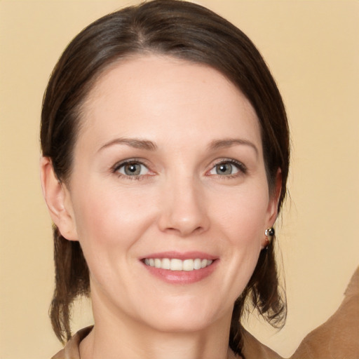 Joyful white young-adult female with medium  brown hair and grey eyes