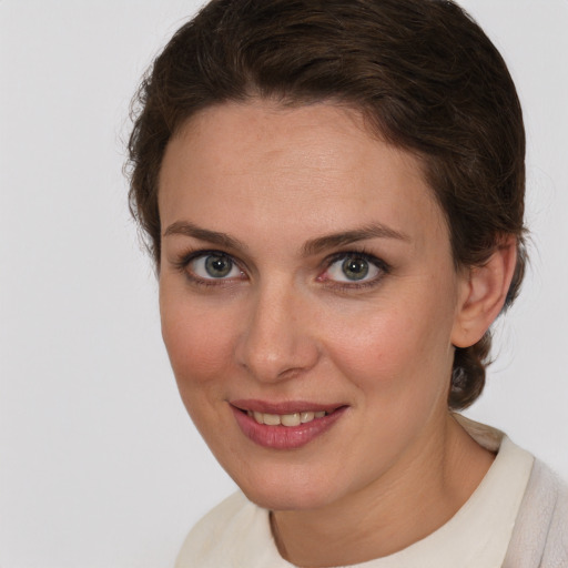 Joyful white young-adult female with medium  brown hair and blue eyes