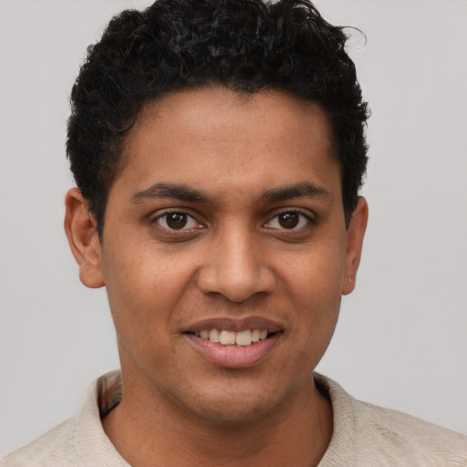 Joyful black young-adult male with short  brown hair and brown eyes