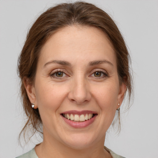 Joyful white adult female with medium  brown hair and green eyes